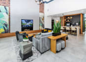 Thumbnail 25 of 46 - a clubhouse living room filled with furniture and a large painting on the wall