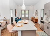 Thumbnail 3 of 46 - a kitchen with a large island with a granite countertop