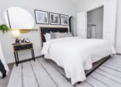 Thumbnail 8 of 46 - a bedroom with a white bedspread and black and white pictures on the wall