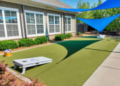 Thumbnail 15 of 54 - Riverstone outdoor game area with cornhole game