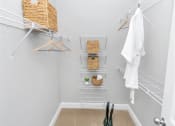 Thumbnail 38 of 54 - Walk-in closet with 3 long shelves on the side and 5 short stacked shelves in the back with baskets