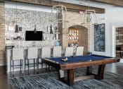 Thumbnail 76 of 78 - a pool table in a living room with a bar and a television