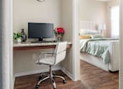 Thumbnail 11 of 30 - a bedroom with a desk with a computer and a bed