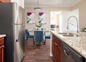 Thumbnail 3 of 30 - a kitchen and dining room with stainless steel appliances and granite counter tops