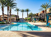 Thumbnail 24 of 30 - a swimming pool with palm trees and buildings in the background