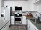 Thumbnail 5 of 34 - Kitchen with white cabinets at Pointe at Lake Crabtree Apartments, Morrisville