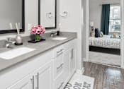 Thumbnail 8 of 34 - Bathroom with vanity and two sinks at Pointe at Lake Crabtree Apartments, Morrisville