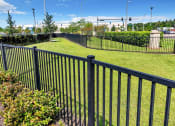 Thumbnail 11 of 32 - a black aluminum fence in a yard with a green lawn