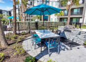 Thumbnail 13 of 32 - a patio with a table and chairs and an umbrella