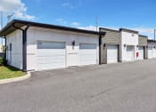 Thumbnail 21 of 32 - a row of garages with white doors and gray siding