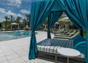 Thumbnail 26 of 32 - a swimming pool with chaise lounge chairs and a table