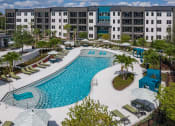 Thumbnail 32 of 32 - an aerial view of the resort style pool with lounge chairs and umbrellas