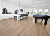 Thumbnail 8 of 37 - a large living room with hardwood floors and a pool table in the middle of the room