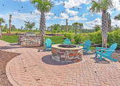 Thumbnail 26 of 37 - an outdoor patio with a fire pit and chairs