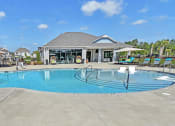 Thumbnail 33 of 37 - a large pool with lounge chairs and umbrellas in front of a building