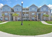 Thumbnail 6 of 37 - an image of an apartment building with a green lawn