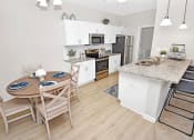 Thumbnail 3 of 37 - a dining area with a table and chairs and a kitchen in the background