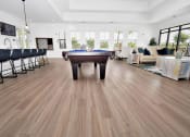 Thumbnail 9 of 37 - a pool table in a living room with hardwood floors