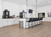 Thumbnail 23 of 37 - a kitchen and living room with hardwood floors and white walls