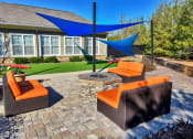Thumbnail 48 of 54 - a patio with a fire pit and lounge chairs in front of a house