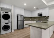 Thumbnail 25 of 36 - A modern kitchen with a large island and stainless steel appliances.