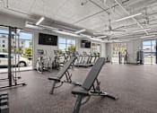 Thumbnail 19 of 36 - A gym with a row of treadmills and a television mounted on the wall.