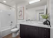Thumbnail 36 of 36 - A white bathroom with a toilet, sink, and a large mirror.