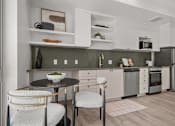 Thumbnail 26 of 36 - A modern kitchen with a table and chairs.