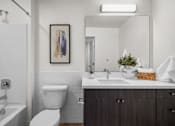 Thumbnail 35 of 36 - A bathroom with a white toilet, a white sink, and a white bathtub.