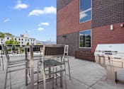 Thumbnail 15 of 36 - A patio with a grill and chairs.