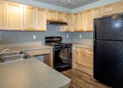 Thumbnail 20 of 20 - a kitchen with wooden cabinets and black appliances