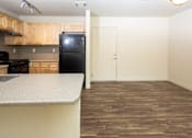 Thumbnail 16 of 20 - a kitchen and living room with wood floors and white walls