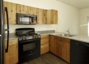 Thumbnail 6 of 10 - a kitchen with black appliances and granite countertops
