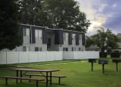 Thumbnail 11 of 32 - an apartment building with a white fence and two picnic tables