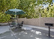Thumbnail 15 of 15 - A patio with a table and chairs and an umbrella.