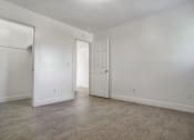 Thumbnail 11 of 14 - A white room with a door and a window.