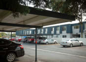 Thumbnail 13 of 32 - a parking lot with cars parked in front of a building