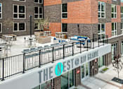 Thumbnail 4 of 36 - The Nest @ Rio Grande is a modern building with a balcony and outdoor seating area.