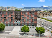 Thumbnail 2 of 36 - A large red brick building with a parking lot in front of it.