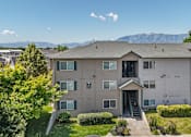 Thumbnail 6 of 29 - A large apartment complex with a mountain range in the background.