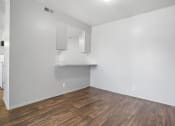 Thumbnail 18 of 32 - an empty living room with white walls and wood floors
