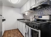Thumbnail 15 of 32 - a kitchen with black appliances and white cabinets