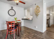 Thumbnail 17 of 32 - a dining area with a table and chairs and a clock on the wall