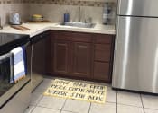 Thumbnail 3 of 4 - a kitchen with stainless steel appliances and a rug on the floor