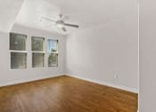 Thumbnail 23 of 31 - an empty living room with a ceiling fan and wood floors
