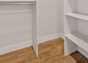 Thumbnail 27 of 31 - a walk in closet with white shelves and a wood floor