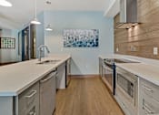 Thumbnail 7 of 31 - a kitchen with stainless steel appliances and white counter tops