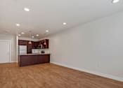 Thumbnail 22 of 31 - an empty living room and kitchen with wood flooring