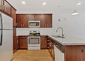 Thumbnail 18 of 31 - a kitchen with wooden cabinets and a counter top