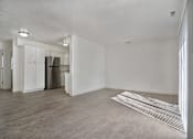 Thumbnail 9 of 14 - A kitchen with white cabinets and a refrigerator is visible.